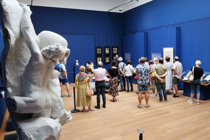Visites commentées©Service Com Mairie de Tarbes Groupe de personnes debout en train d'assister à une visite commentée dans la salle des beaus-arts du Musée Massey