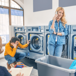 Un homme et une femme attendent leur linge dans une laverie automatique