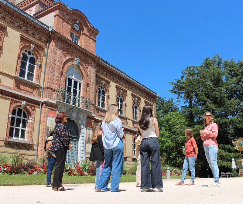 Un groupe de personnes se promène au milieu de la végétation luxuriante et des fleurs colorées du jardin Massey